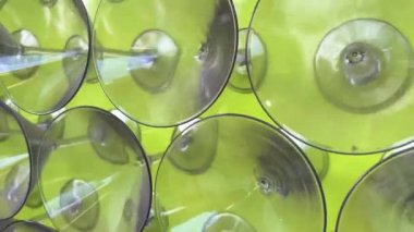 A lot of Martini glasses stand in a row. The camera slowly floats to the top, filming all of them. On a light green bright background Background for any text for advertising Volumetric background