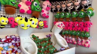 Among the toys are two toilet bowls Amusement parks in prizes that are issued for winning Many soft toys located on the shelves are the same and bright Every child and adult wants to win. 