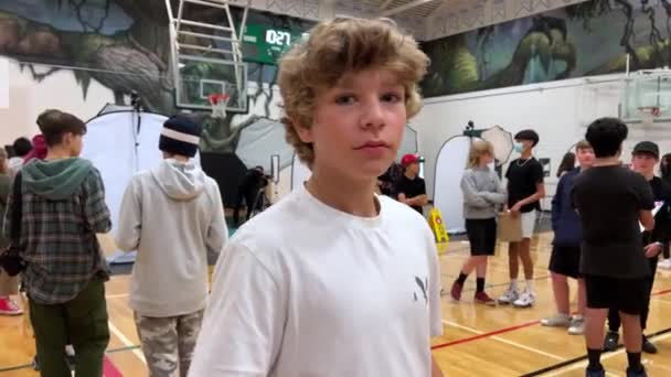 Boy Standing Gym School Raises His Arms Sides One Hand — стоковое видео