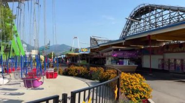 Boş koltukların döndüğü salıncak zinciri gökyüzünün arka planında mutluluk ve neşe beklentilerini kontrol etmek için parkı hazırlıyor Britanya Kolumbiyası 'nın tüm renkleri, Kanada 08.2022