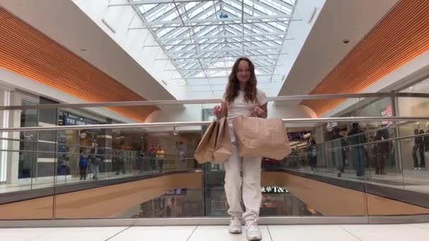 Een Tienermeisje Staat Met Tassen Haar Handen Tegen Een Grote — Stockvideo