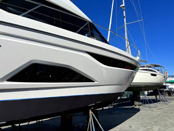 Rich life of luxury granville island Two beautiful ships stand on a raised platform prepared for repairs good weather bright clear sky Yacht travel Canada Vancouver 09.2022