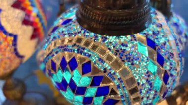 Mağazada çok renkli parlak Türk lambaları farklı renklerde parlıyor. Mozaik renkli yıldızlar ve lambaların üzerine boyanmış çiçekler.
