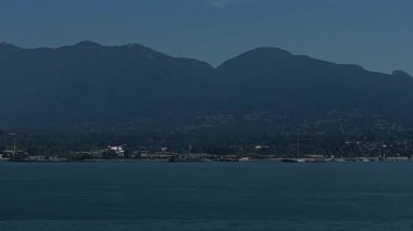 Sisli denizle kaplı ve uzak yılların yanı sıra küçük bulutlu mavi gökyüzü büyük Vancouver Canada şehrinde doğanın dipsiz güzelliği. Yüksek kalite 4k görüntü