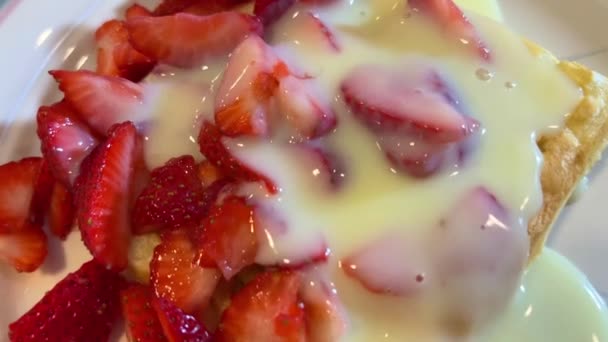 クリームブリュレのイチゴワッフルの上に横たわるおいしい食欲をそそるデザートカメラはゆっくりと泳ぎながら上から撮影 — ストック動画