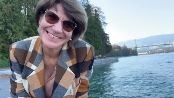공원에 태평양 연안의 코트를 여성은 머리를 가지고 — 비디오