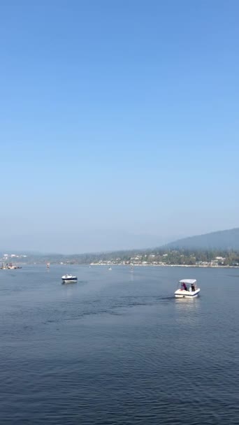 Les vagues lentes divergent du bateau passant devant le port lunatique Esplanade Ave Rocky Point Park Jetée récréative Calme encore bleu l'eau et le ciel Le brouillard ou la fumée d'un bateau à moteur forestier en feu n'est qu'un seul vivant