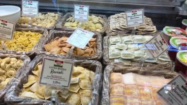 Donmuş yarı bitmiş ürünler, dolma dolma dolma dolma biberler, lahana ruloları, hamur tatlısı ve krepler markette ya da ev mutfağındaki masanın üzerinde duruyor. Dolly vurdu. Yakın plan. Yüksek kalite 4k görüntü