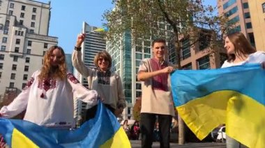 Ukraynalılar Ukrayna 'da Ukrayna bayrağı standında barışın sona ermesini bekleyen ve Ukrayna bayrağını taşıyan Ukrayna ulusal kıyafetlerinde farklı yaşlardan 4 kişiyi desteklemek için toplandılar.