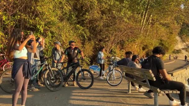 秋の大きな山と太平洋の人々が座っています彼らは自転車で旅行し 夕方に日没を待つ太陽は彼らの顔を照らすスタンレーパークバンクーバーカナダ08 2022 — ストック動画