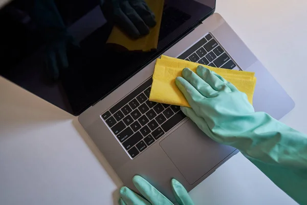 Laptop dezenfekte ediliyor. Evde dizüstü bilgisayar temizliği. Ofiste dizüstü bilgisayar temizliği. Dizüstü bilgisayar klavyesi siliniyor