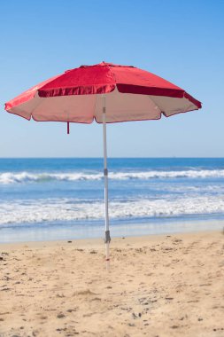 Kumsaldaki kırmızı plaj şemsiyesi