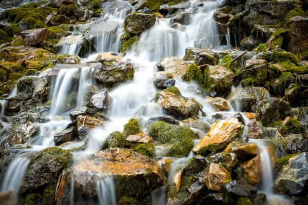 Lange Belichtung Von Flüssen Die Moosbewachsene Felsen Hinunterfließen — Stockfoto