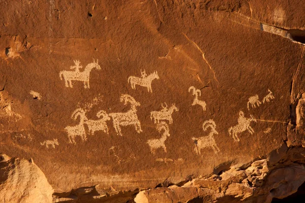 ABD 'nin Utah eyaletindeki Arches Ulusal Parkı' nda hayvan petroglifleri bulunan turuncu kumtaşı kaya duvarı.