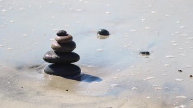 Okyanus dalgaları bir zen cairn 'e çarpar.