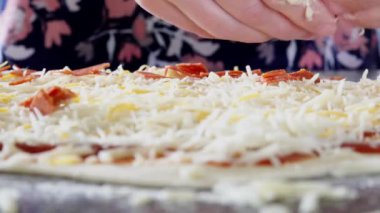 Ev yapımı pizzaya pepperoni serpiştiriyorum.