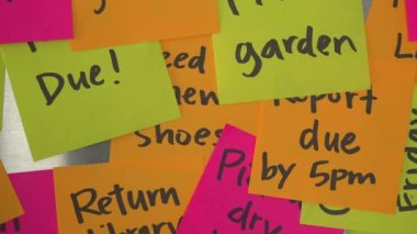 Camera Dolly Left Past Stacked Reminder Notes and Hand Adds Memo That Says Schedule Time to Relax