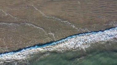 Drone Aerial With Camera Facing Downward Flying Parallel With Waves Along Beach Coastline