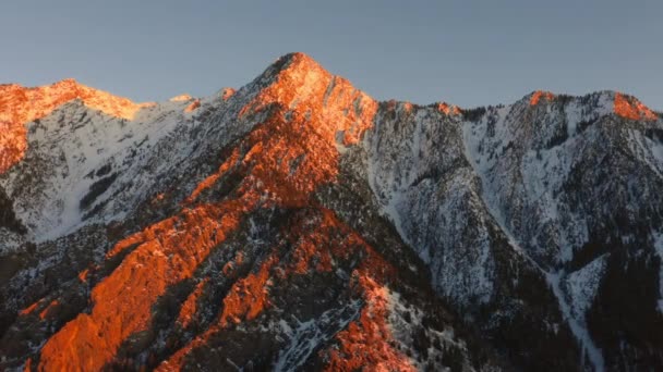 Drone Aerial Circling Sunset Illuminated Mountain Peak Covered Snow Wintertime — Wideo stockowe