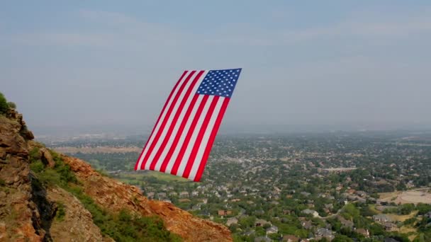 Беспилотник Вращается Вокруг Американского Флага Висящего Между Горными Скалами — стоковое видео