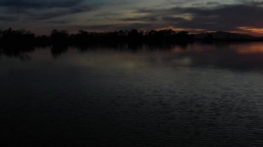 İHA Göl yüzeyinden günbatımına doğru ilerliyor.