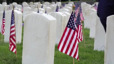 Man Walks up to Military Headstone