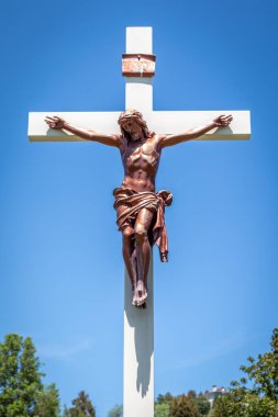 Gold colored statue at a cemetery of Jesus Christ hanging on the cross