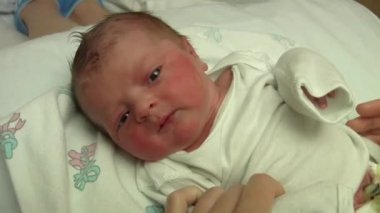 Sevimli yeni doğmuş bebek annesinin kucağında yatıyor.