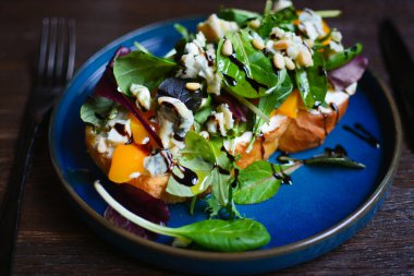 Mavi tabakta yeşil salata, ıspanak ve süzme peynir.