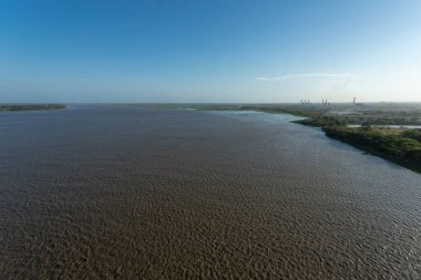 Magdalena Nehri kıyıdan görünen mavi gökyüzü manzaralı. Barranquilla, Atlantico, Kolombiya. 
