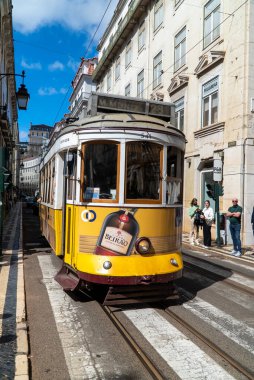 Lizbon, Portekiz. 10 Nisan 2022: Ünlü sarı tramvay ve şehir mimarisi.