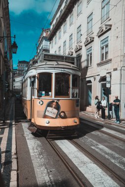 Lizbon, Portekiz. 10 Nisan 2022: Ünlü sarı tramvay ve şehir mimarisi.