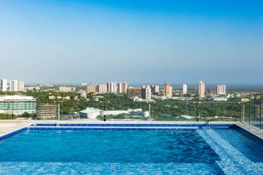 Barranquilla, Atlantico, Kolombiya. 30 Temmuz 2022: Bir binadan yüzme havuzu ve güzel mavi gökyüzü olan şehre doğru görüş.
