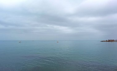 Görüntü: Sabah gökyüzünün önü açık beyaz bulutlarla parlak mavi. Ve gün ışığında çivit balığının okyanus derinlikleri. Sakin, sakin, rahatlatıcı bir duygu..