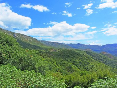 Vadinin üzerinde bir dağ duvarı yükseliyor. Güneşli bir günde, tepelerde küçük bir köyle ılık bir ton. Dağlar granit gibi.