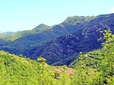Vadinin üzerinde bir dağ duvarı yükseliyor. Güneşli bir günde, tepelerde küçük bir köyle ılık bir ton. Dağlar granit gibi.