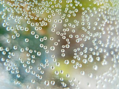 Renkli arka planda cam üzerine hava damlaları.