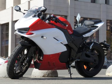 Red white italian sportbike on the street. Beautiful motorcycle in the colors white and orange parked on the street