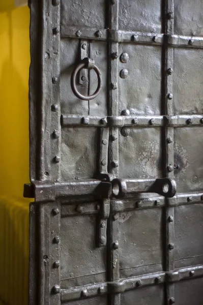 A medieval black door with a deadbolt. Old wooden iron entrance door with antique door handle. old door handle for wooden gates