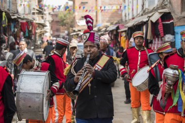 Katmandu, Nepal - 20 Mart 2022: Düğün alayı Patan Durbar Meydanı sokaklarından pirinç müzik eşliğinde geçer ve geleneksel giysiler giyen insanlar.