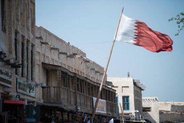 Doha, Katar, Nisan 01.2022: Katar ulusal bayraklarıyla süslenmiş eski pazar Souk Waqif.