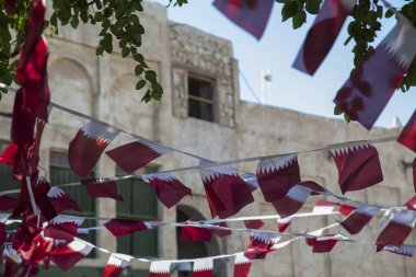 Doha, Katar, Nisan 01.2022: Katar ulusal bayraklarıyla süslenmiş eski pazar Souk Waqif.