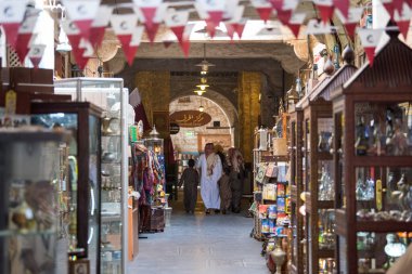 Doha, Katar - 05 Mart 2019: Geleneksel giyimli Katar ailesi eski pazar pazarı Souk Waqif 'te takılıyor.