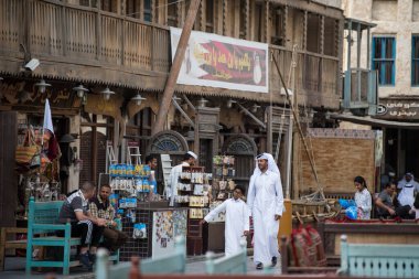 Doha, Katar - 05 Mart 2019: Geleneksel giyimli Katar ailesi eski pazar pazarı Souk Waqif 'te takılıyor.