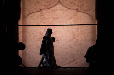 Doha, Katar - 05 Mart 2019: Geleneksel giyimli Katar ailesi eski pazar pazarı Souk Waqif 'te takılıyor.