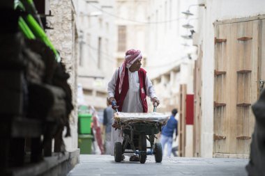 Doha, Katar - 25 Mayıs 2018: Souk Waqif 'teki Wheel Barrow işçisi, bu işçiler geleneksel zamanlardan beri mal yüklemek için kullanılıyor.