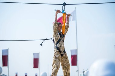 Doha, Katar, 18 Aralık 2019. Katarlı çocuklar Katar ulusal gününü kutlamak için yapay bir kondominyum askeri eğitim sahasında oynuyorlar..