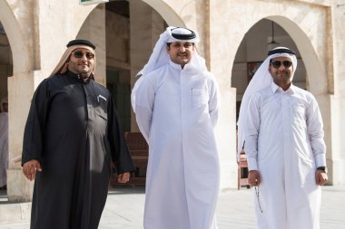 Doha, Katar - 15 Nisan 2022: Geleneksel giyimli Katar yerlileri eski pazar pazarı Souk Waqif 'te takılıyorlar.