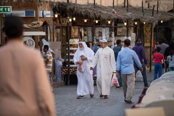カタールのドーハ 2022年4月15日 伝統的な衣装を着たカタールの地元の人々が古いバザール市場でたむろする Souk Waqif — ストック写真