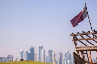 Doha, Katar - 24 Nisan 2022: Arka planda Doha 'nın fütüristik silueti olan geleneksel dhow gemileri.